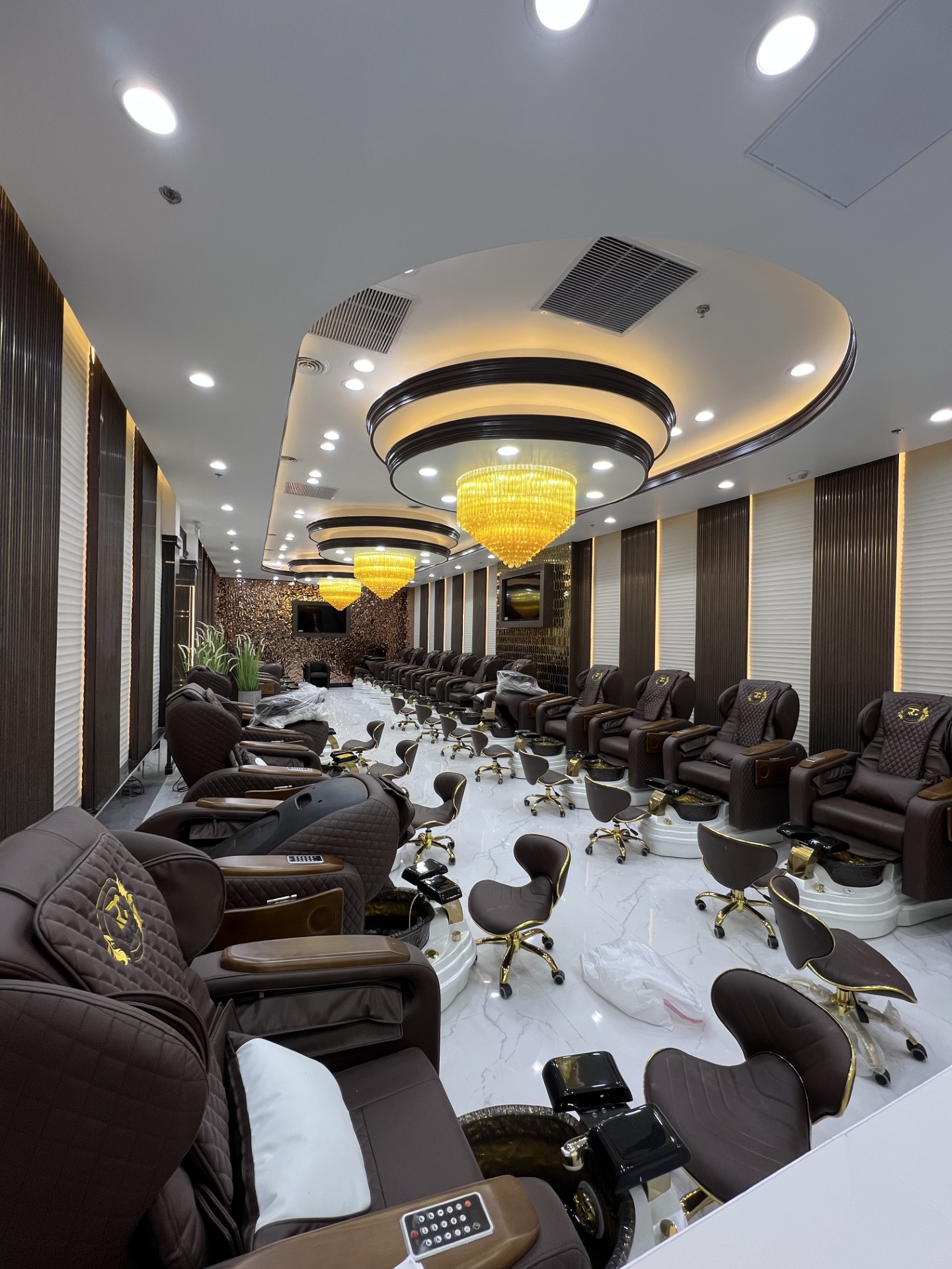 Long pedicure gallery with oval feature ceilings and gold chandeliers